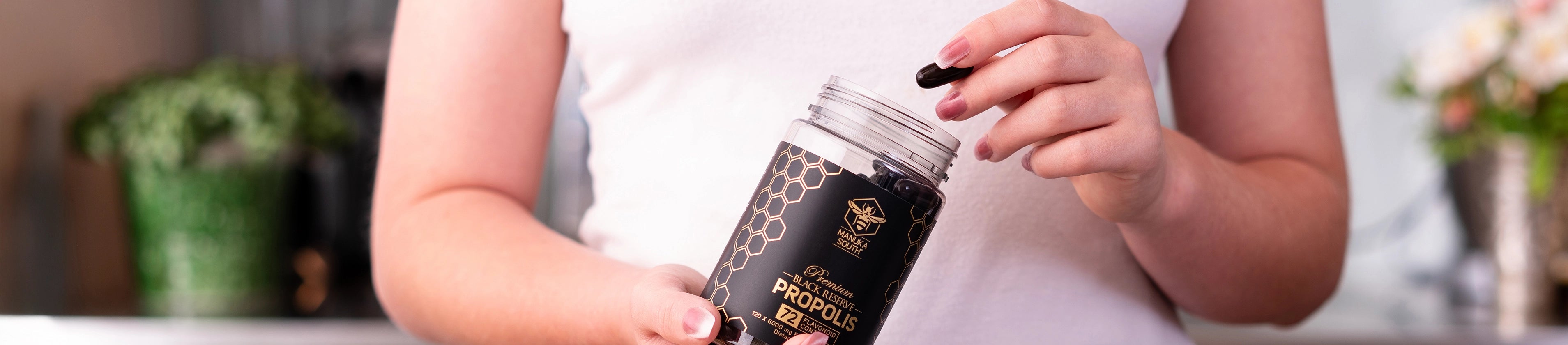Person holding a jar of protein powder with a blurred background