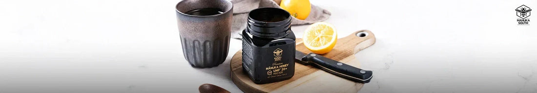 Jar of Manuka honey on a wooden board with a lemon and a cup, for a guide to manuka honey by MGO rating