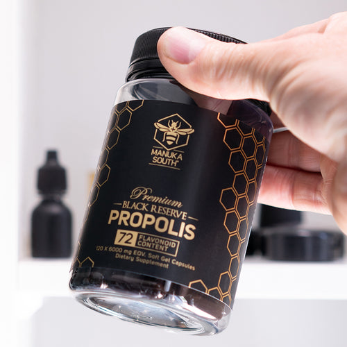 person holding a bottle of black reserve propolis