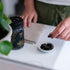 woman picking up a capsule of propolis from a small bowl