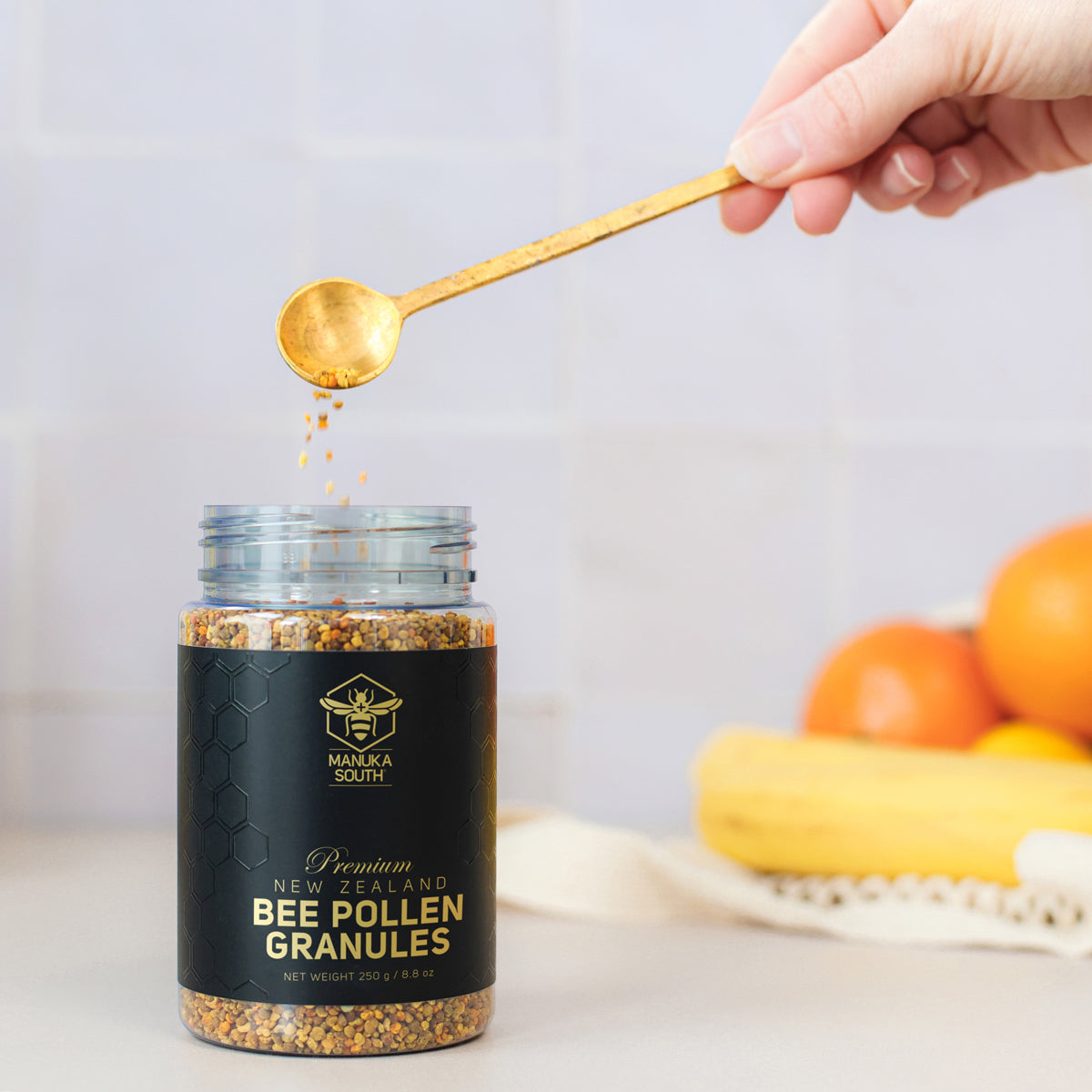 person using spoon to get bee pollen granules from the bottle