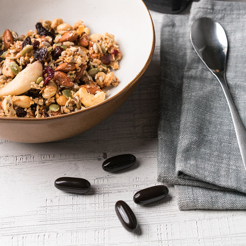 Black Reserve Propolis Capsules on table with breakfast bowl