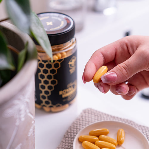 woman holding a capsule of royal jelly