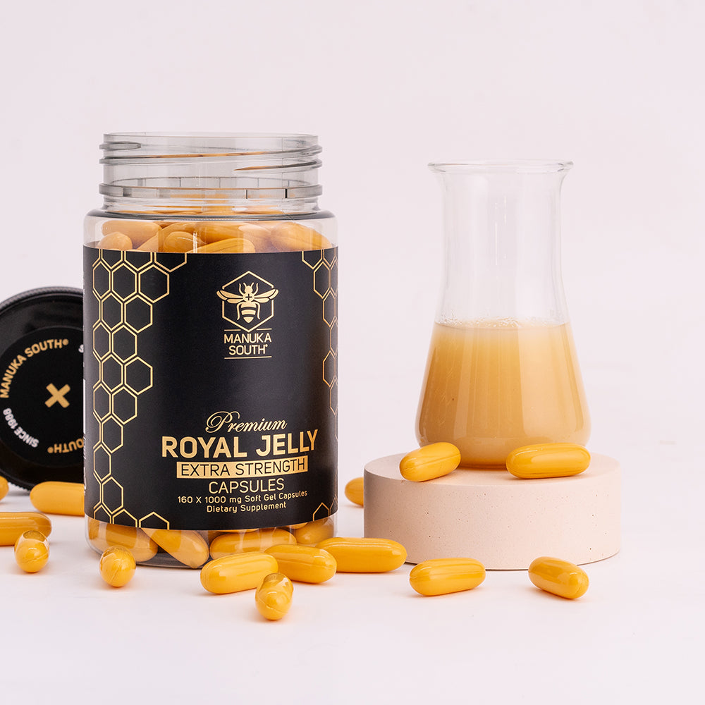 royal jelly capsules scattered on a table; opened royal jelly bottle