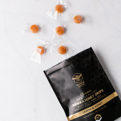Manuka honey drops on a table with the pouch below them