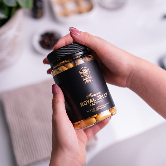 woman holding a bottle of royal jelly capsules