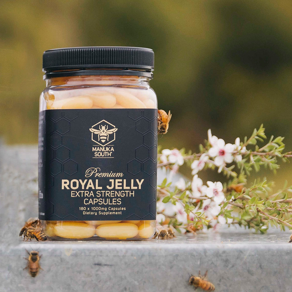 Extra Strength Royal Jelly Capsules jar on beehive with Manuka Flowers