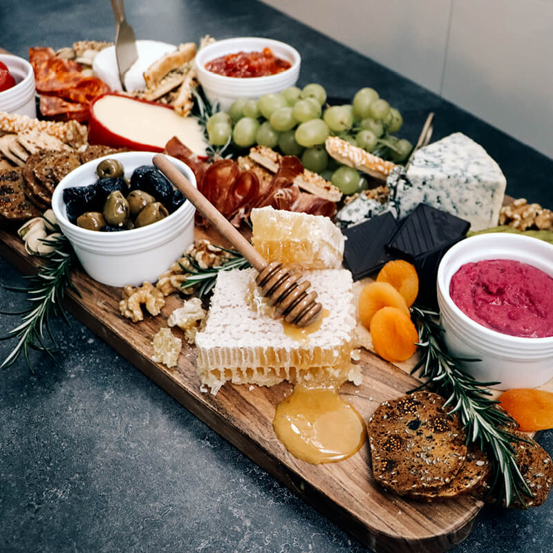
                  
                    Cheeseboard platter with assortment of snacks, cheeses and honeycomb
                  
                
